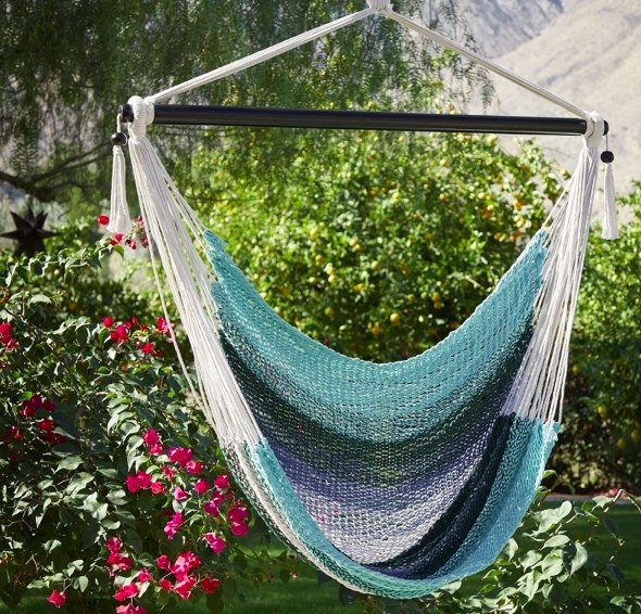 the blue striped hammock hanging in a garden