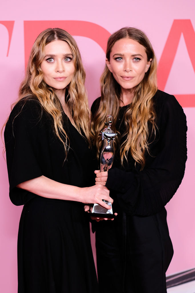 Mary-Kate and Ashley Olsen holding an award