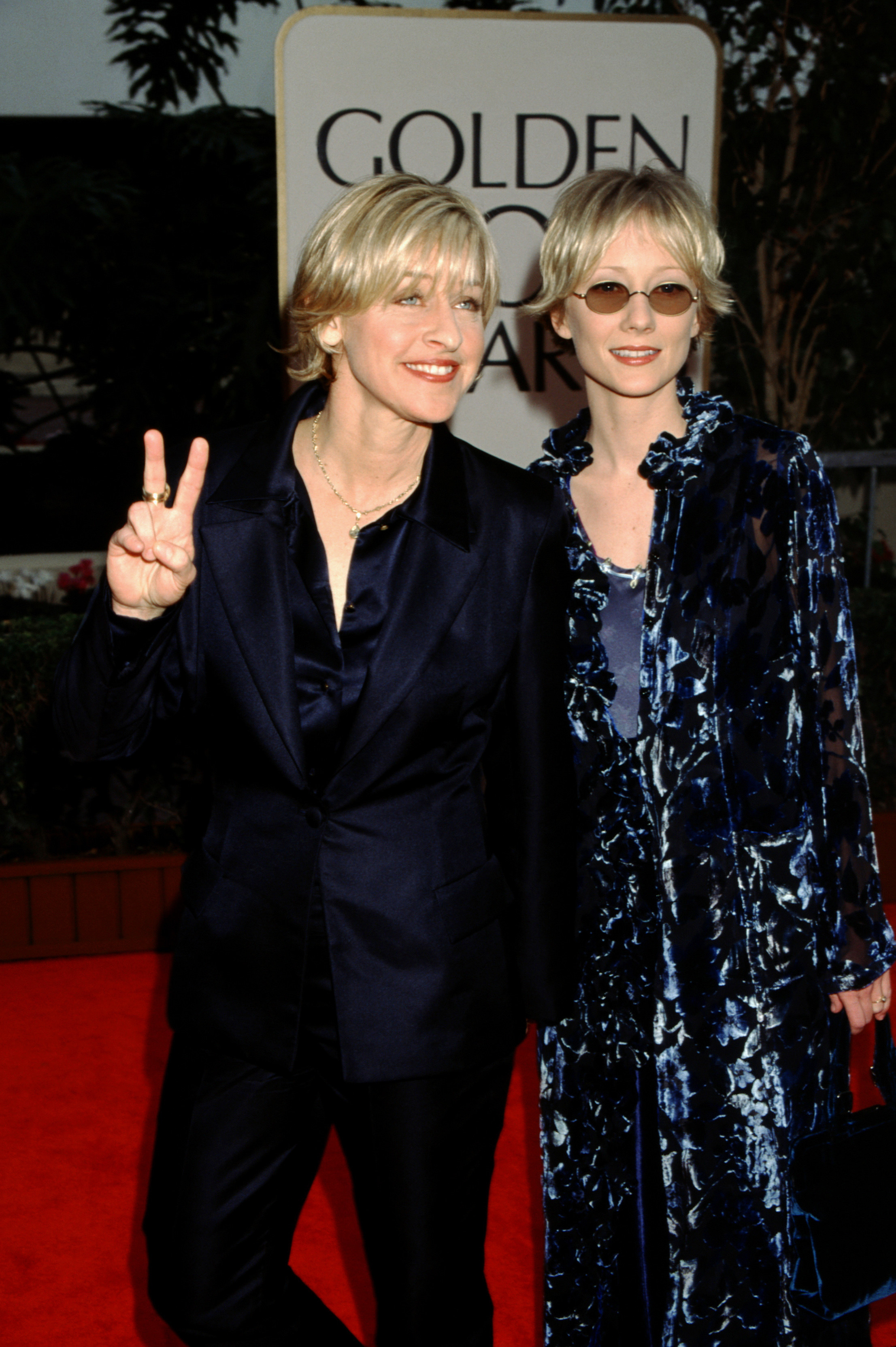 Ellen and Anne walking the Golden Globes red carpet as Ellen gives the peace sign