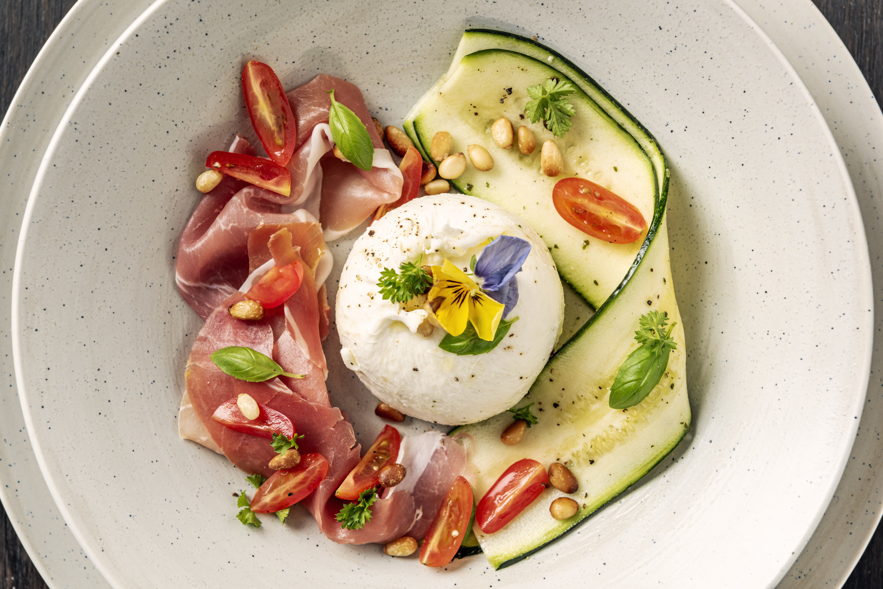 Antipasta salad with pesto, pine nuts, Burratini, fresh tomatoes, and more.