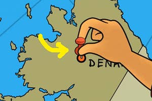 someone putting a pin on denmark on a map