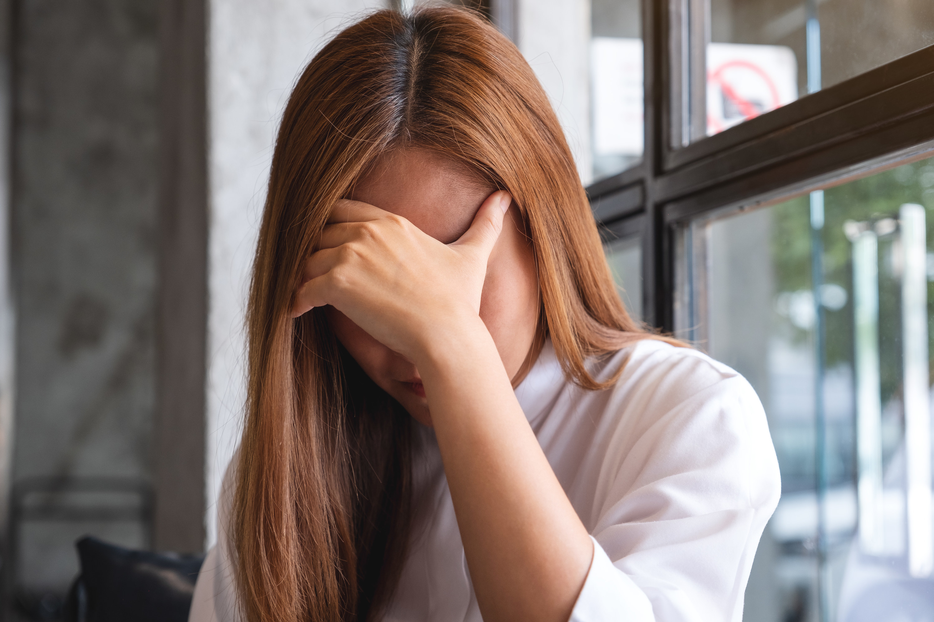 Woman covering her face with her hand