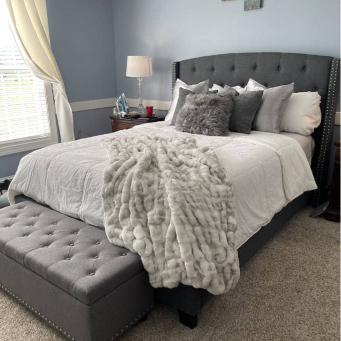 Light gray faux fur throw blanket on bed