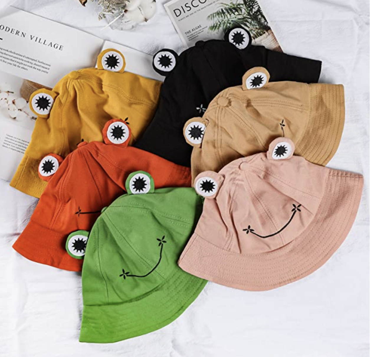 The frog hats all laying on a bed