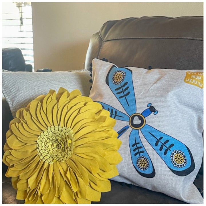 Yellow flower throw pillow next to blue dragonfly pillow