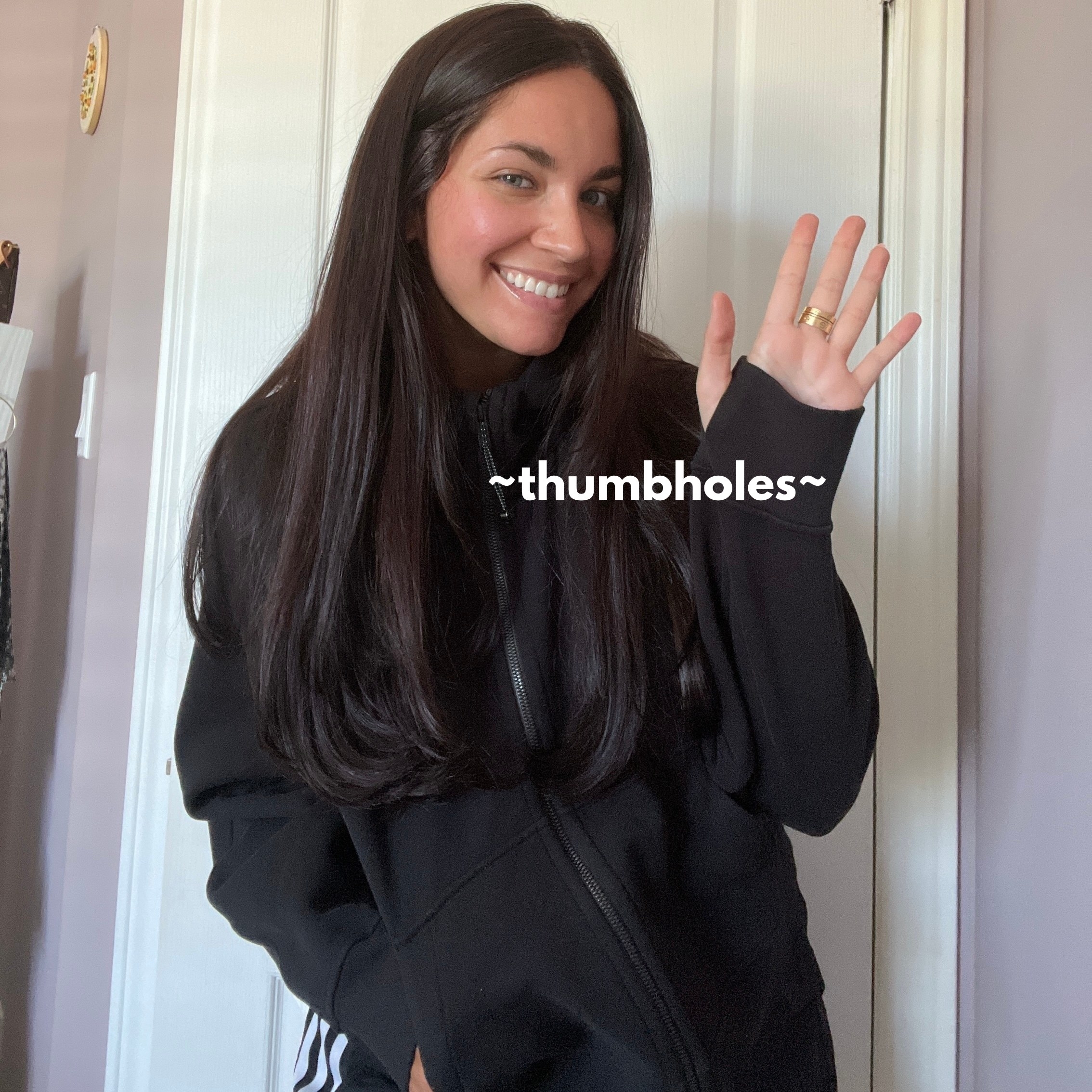 Melina wearing the sweater and showing off the thumbholes