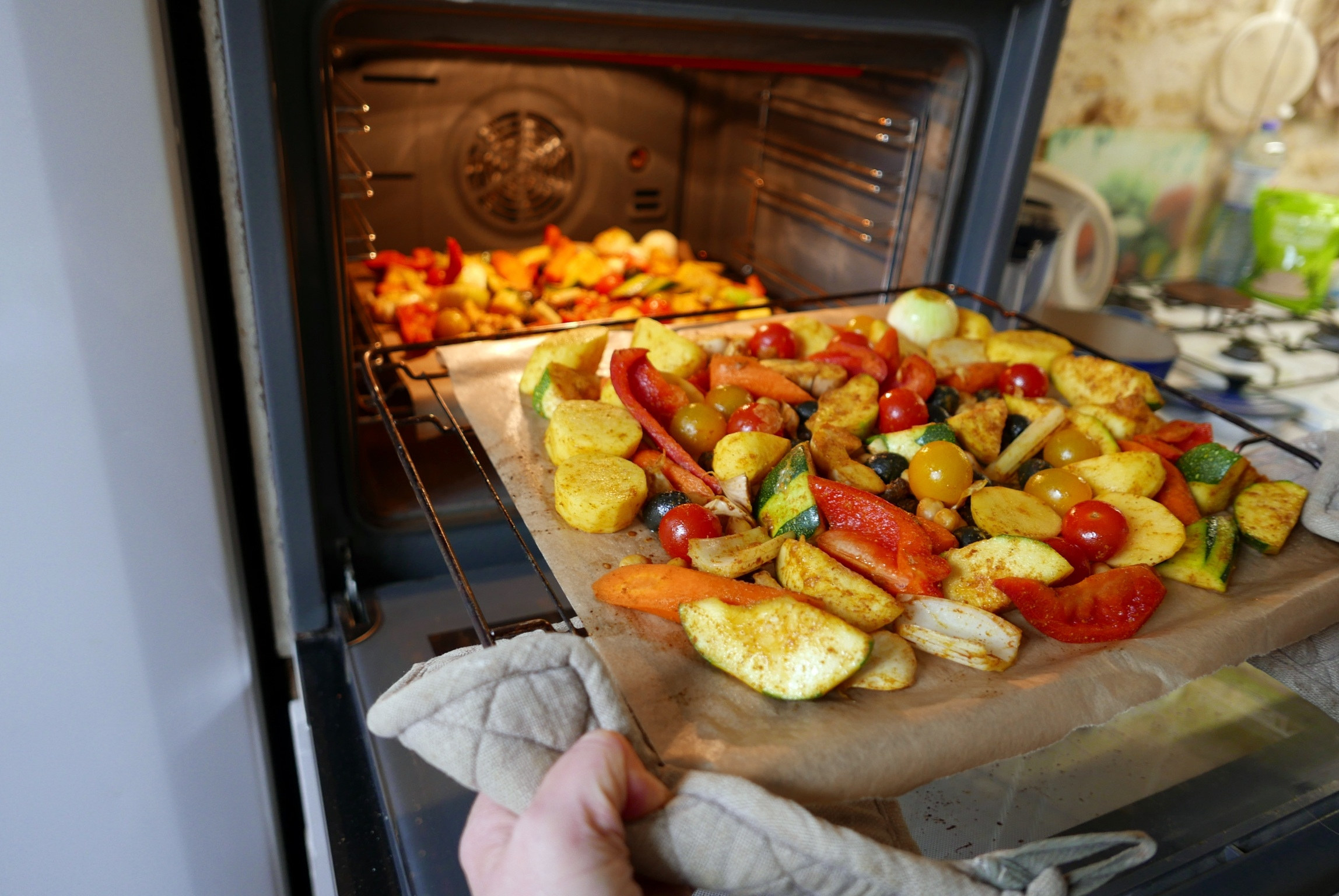 Removing vegetables from the oven.