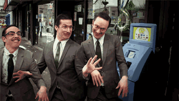 three guys with mustaches wearing suits and glasses dancing together