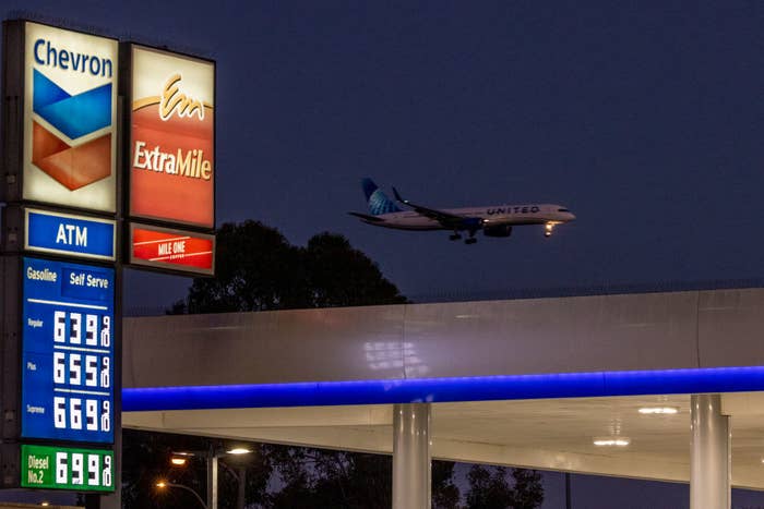 plane flying over a gas station with prices starting at $6.39