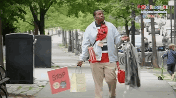 A man running his errands while carrying dry cleaning, bags, and water