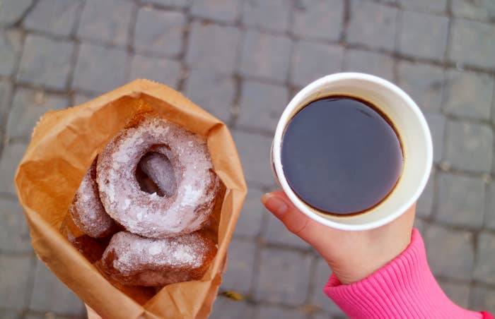 Person holding donuts and coffee