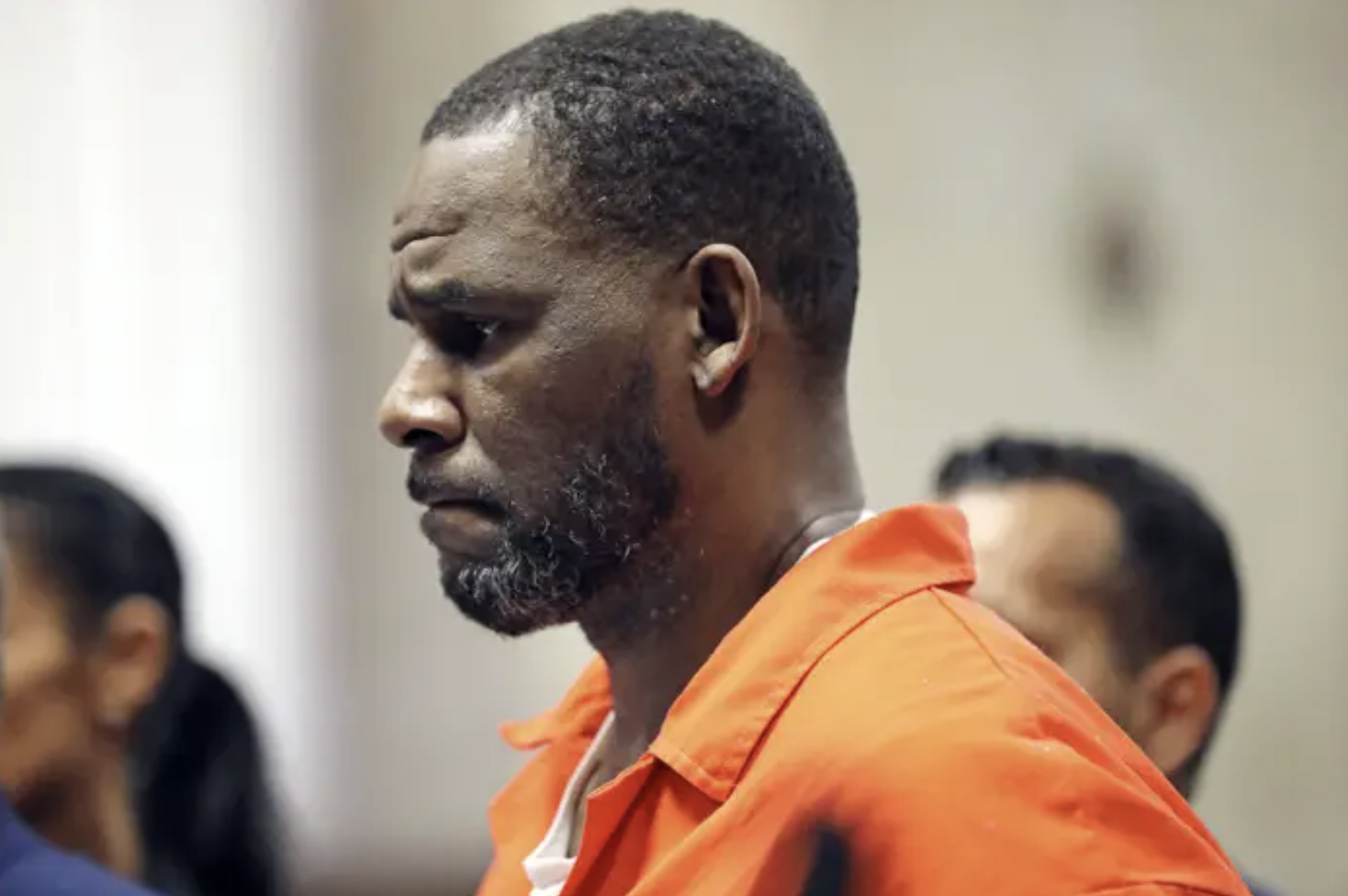 R. Kelly&#x27;s side profile in an orange jumpsuit in a courtroom