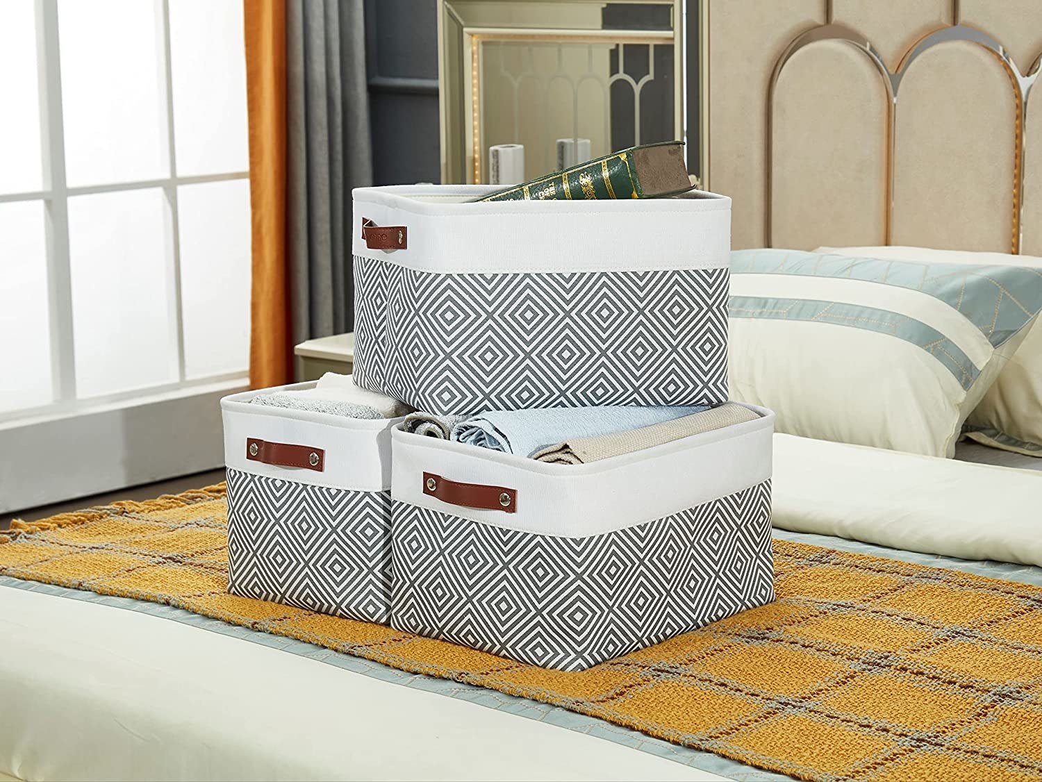 three fabric baskets on a bed