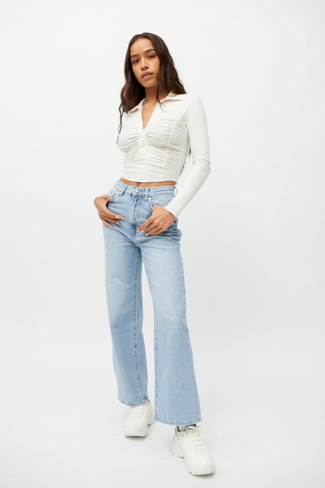 model in light wash high waisted wide legged jeans
