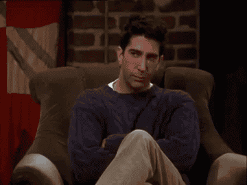 A GIF of Ross from Friends sitting in his chair and rolling his eyes