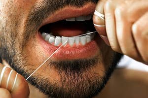 A close up of a man flossing