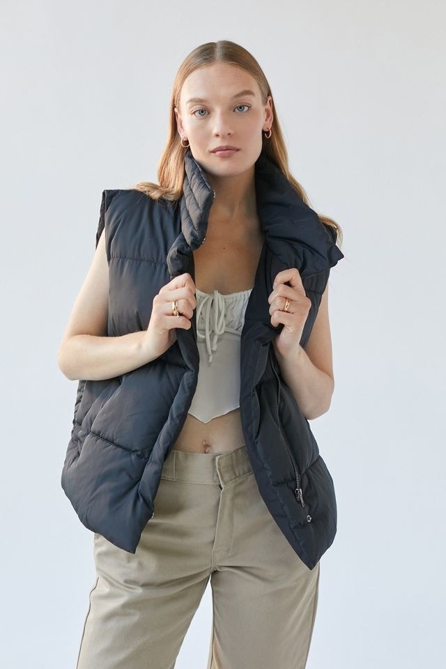 model in black puffer vest with a high collar