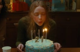 A close up of Sadie Sink blowing out birthday candles