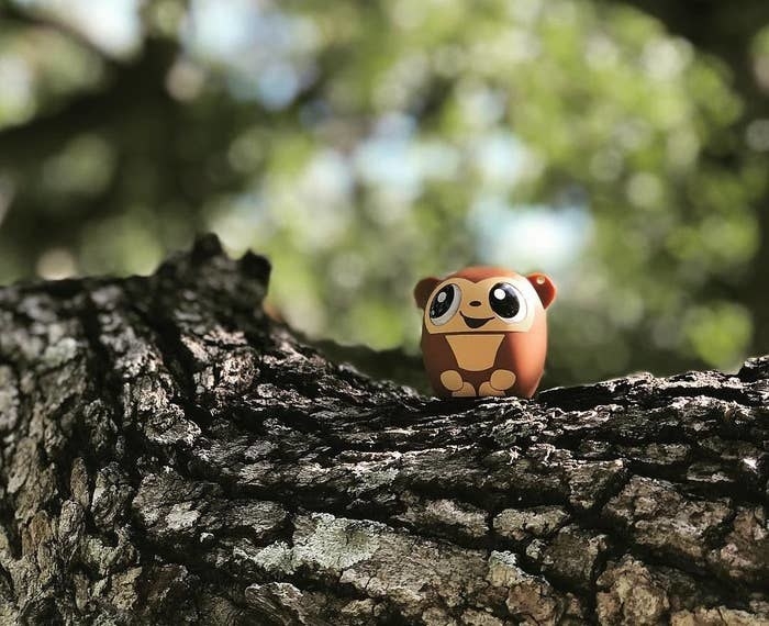 a tiny speaker on a tree shaped like a monkey