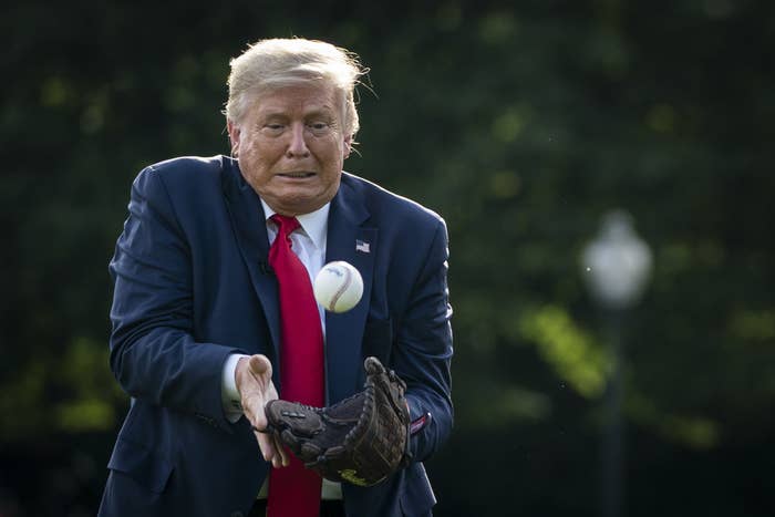 Trump grimaces as he catches a baseball