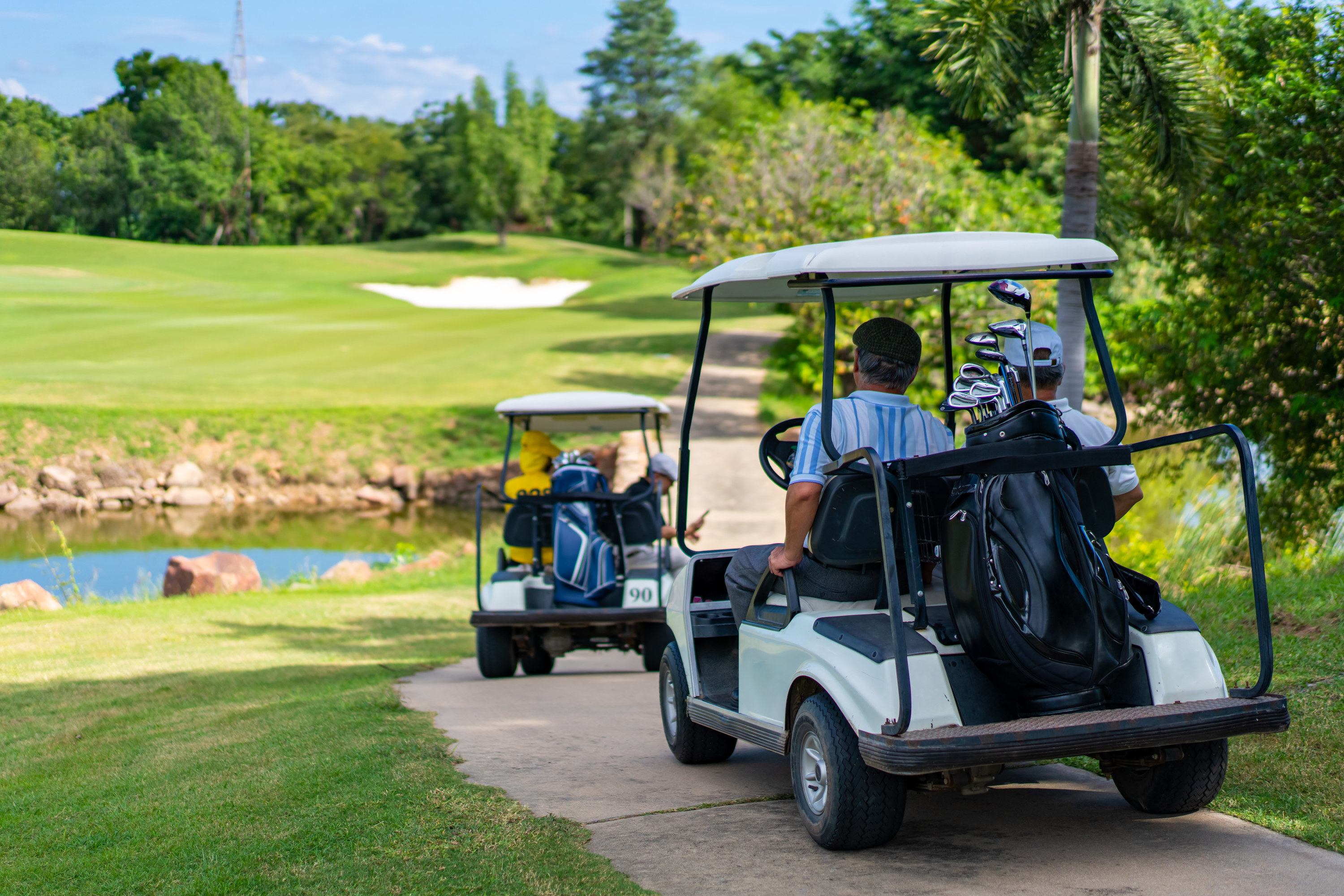 two golf carts driving down a trail