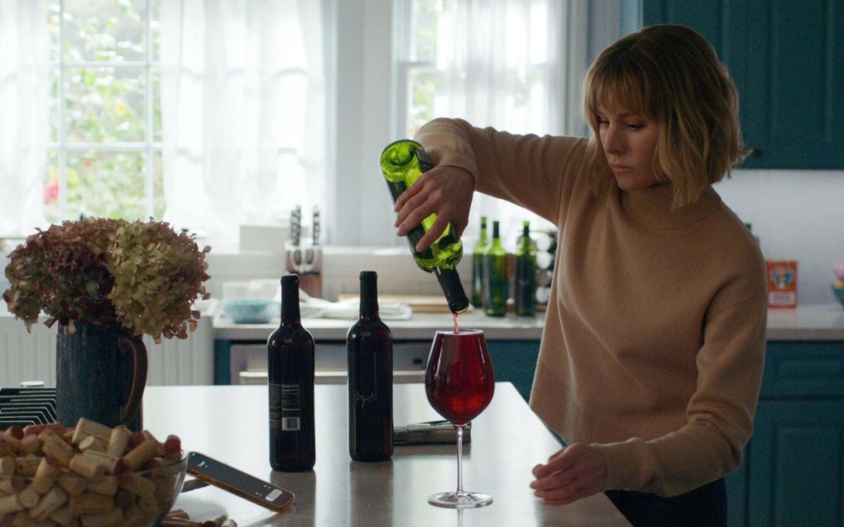 Kristen Bell as Anna in &quot;The Woman in the House Across the Street&quot; pouring a large glass of wine