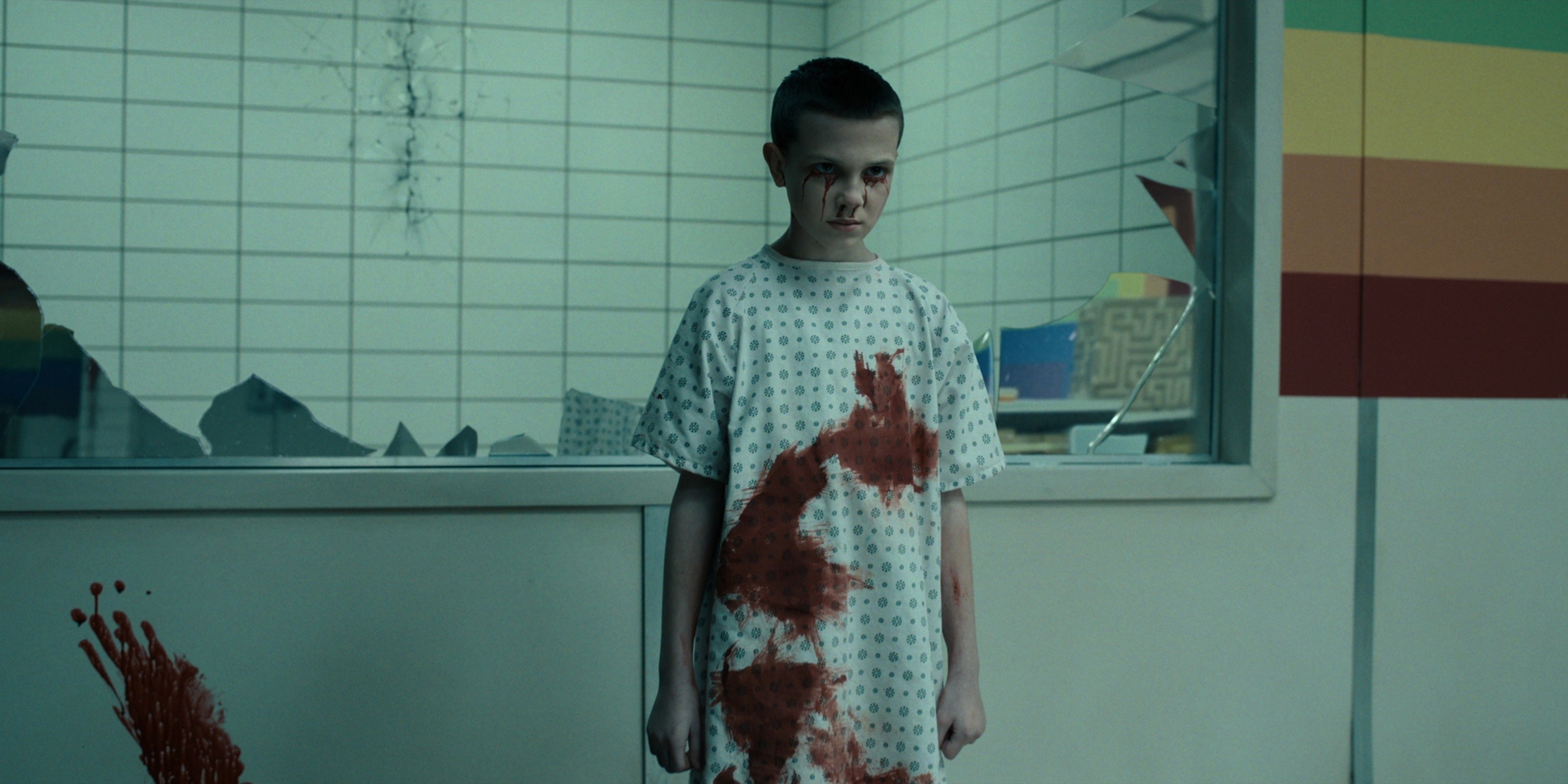 Millie as Eleven in Stranger Things wearing a hospital gown covered in blood