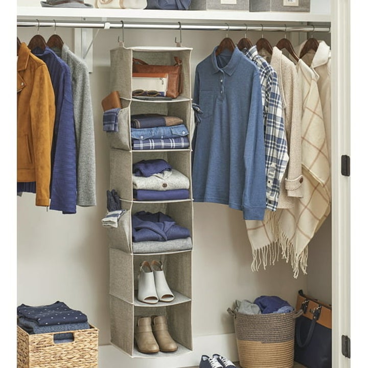 the hanging organizer in a closet holding shoes and shirts