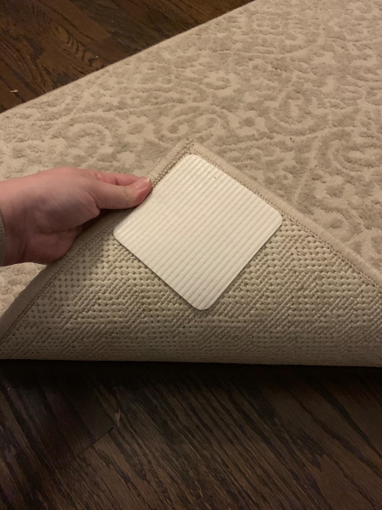 Reviewer holding rug corner with rug gripper stuck to the corner