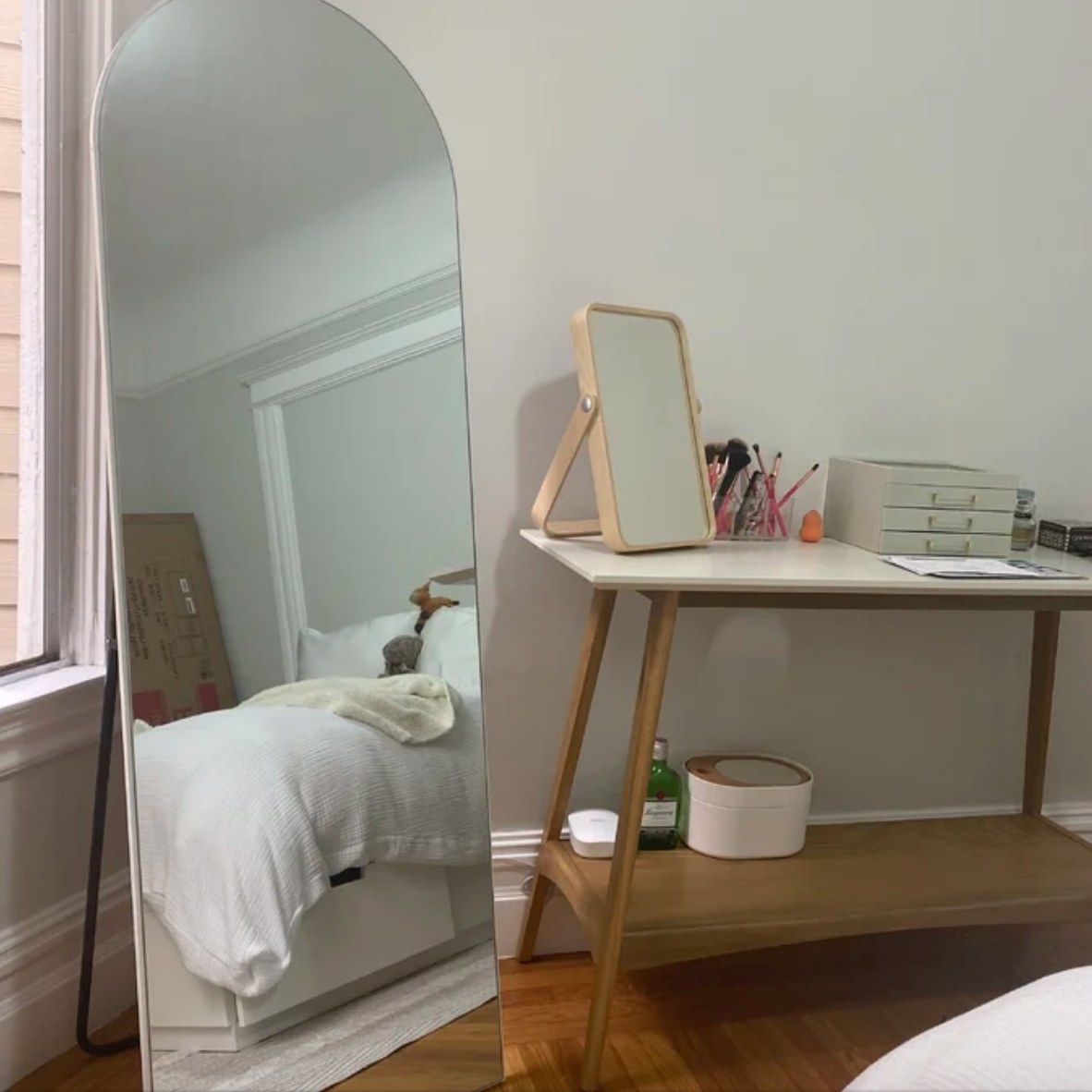 White floor mirror in room next to desk