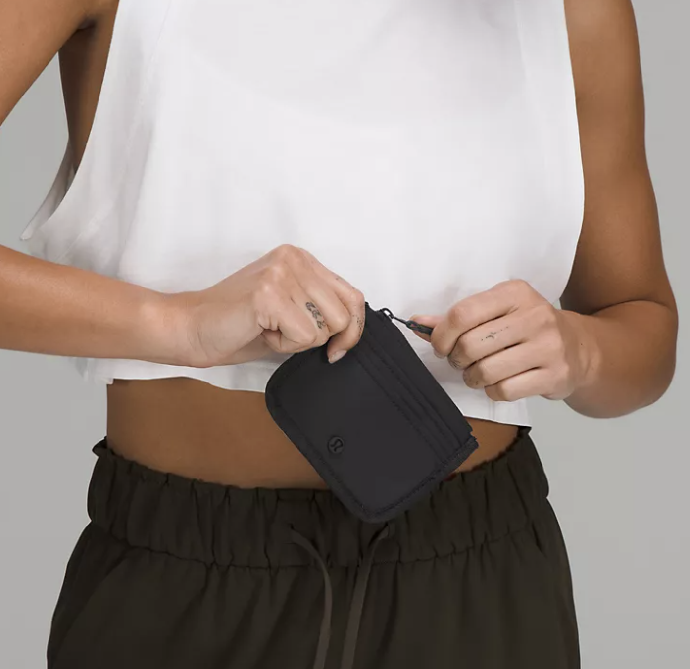 A person undoing the zipper on the card case