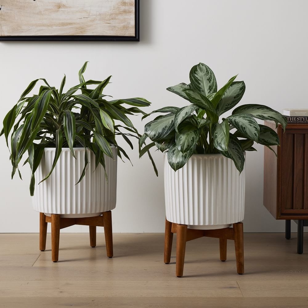 a pair of white mid century planters on wooden stands