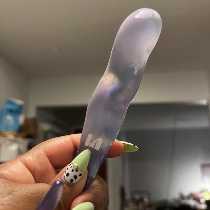 Hand holding frosted glass dildo