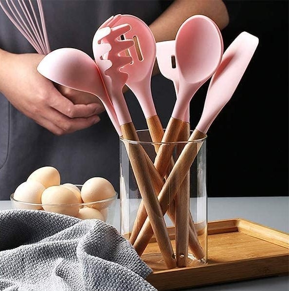 a set of silicone tipped kitchen utensils in a glass crock