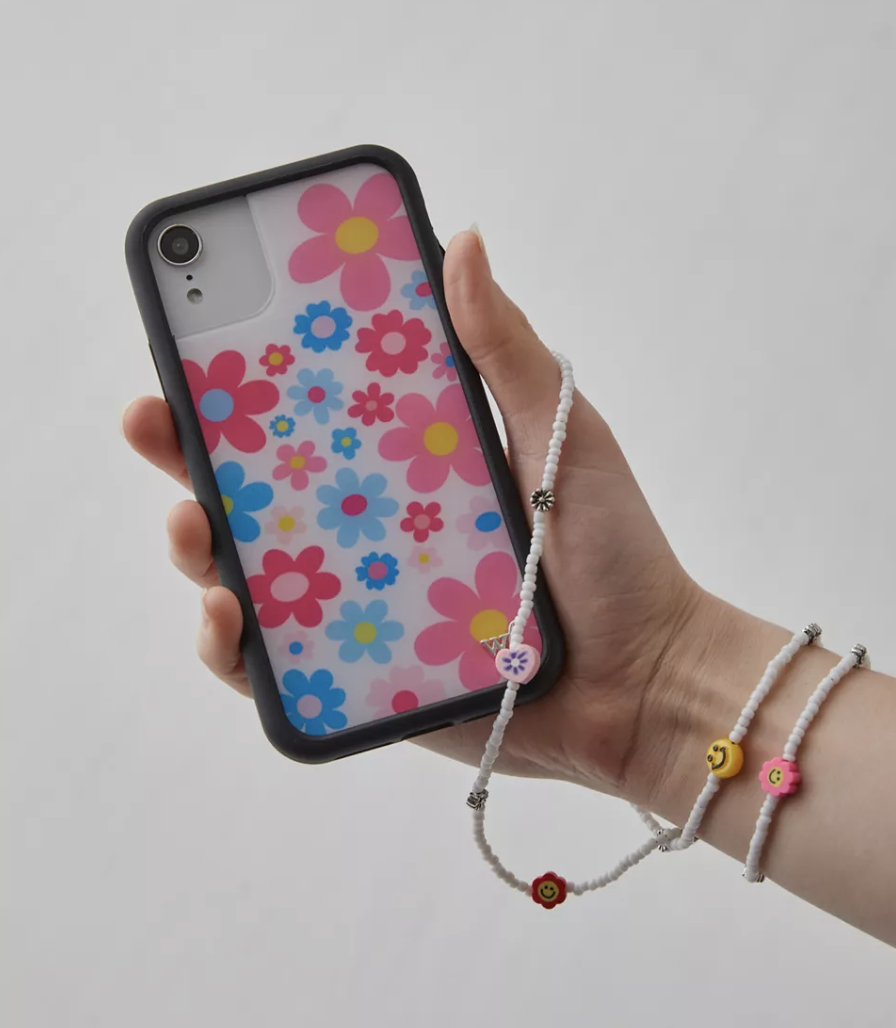 a person holding up the floral print phone case