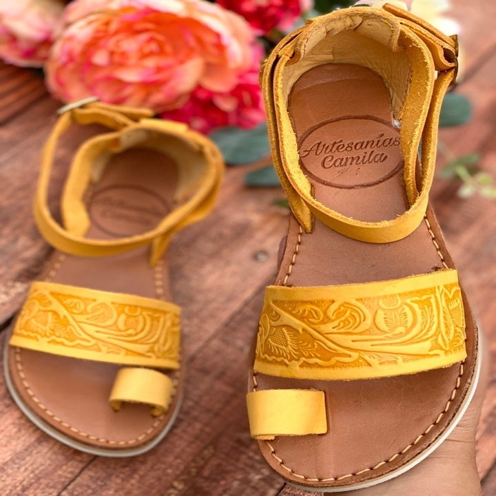 a pair of hand-tooled yellow leather sandals