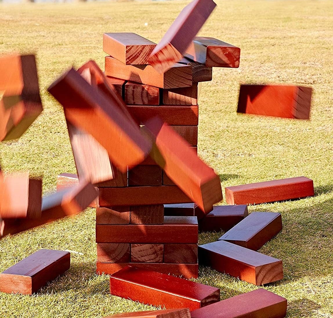 a giant tumble tower game falling down on grass