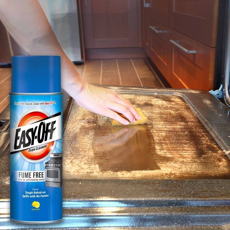 a model using a sponge on a dirty oven door, with the blue bottle of oven cleaner edited on the left of the photo