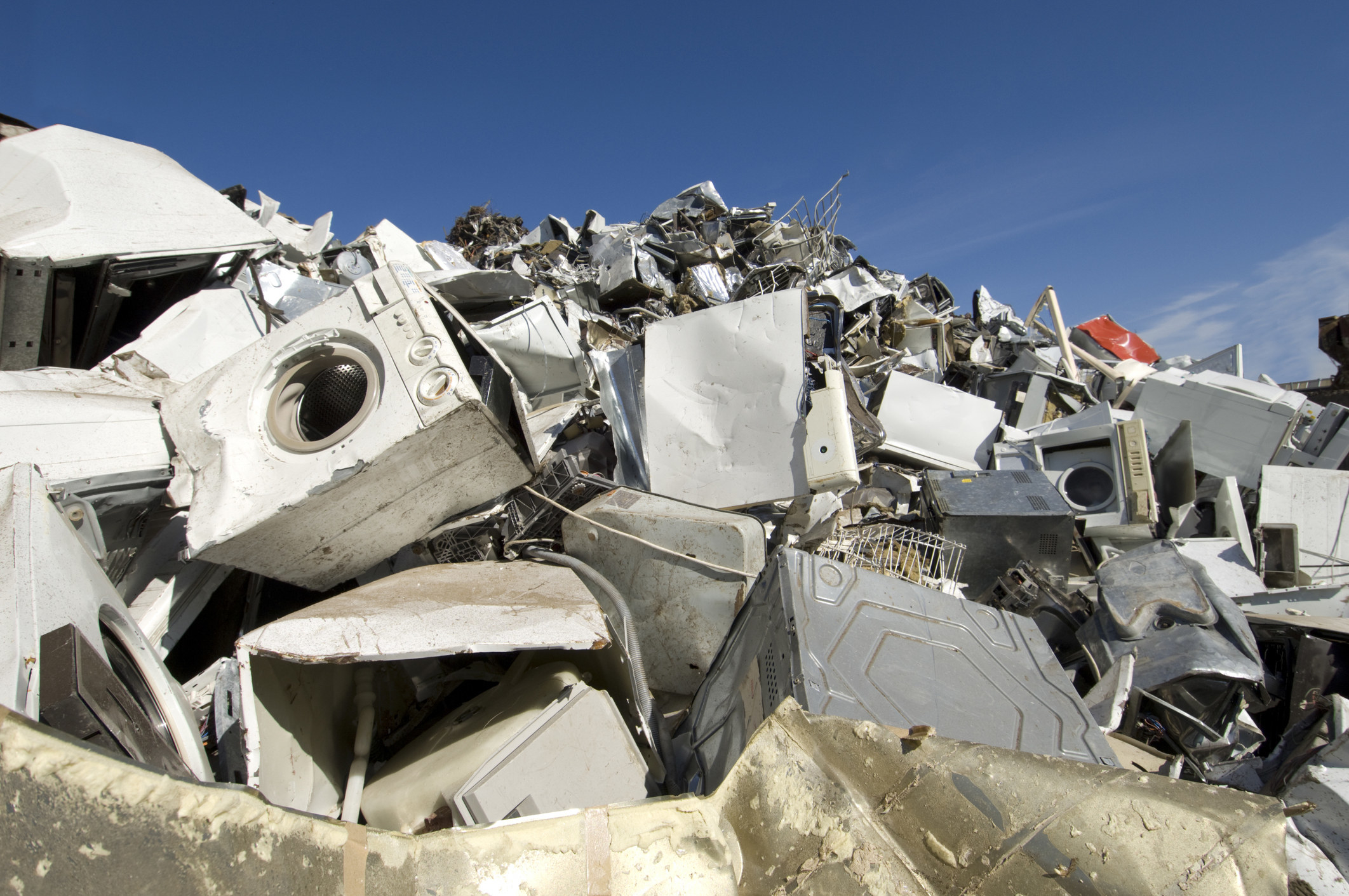 A pile of broken appliances at a junkyard