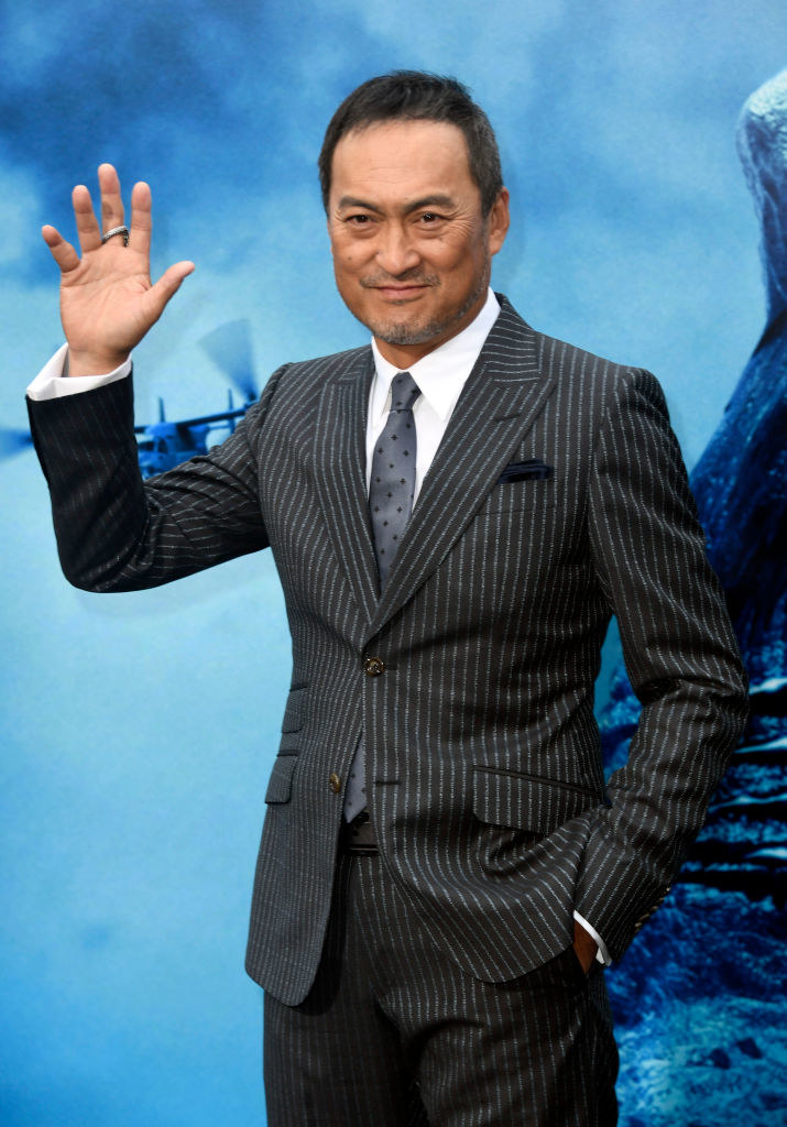 Waving and wearing a suit with tie