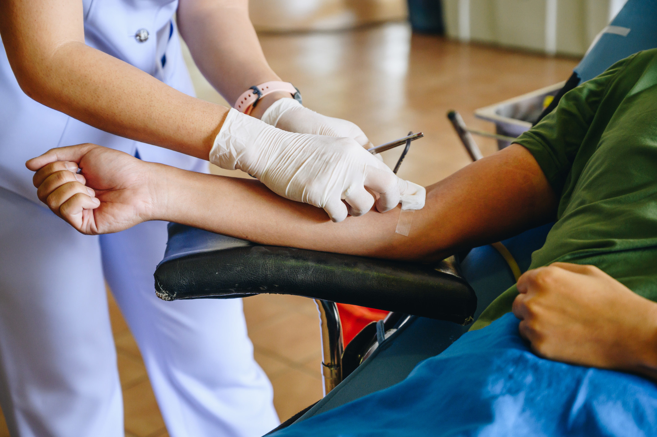 Someone taking blood from a patient