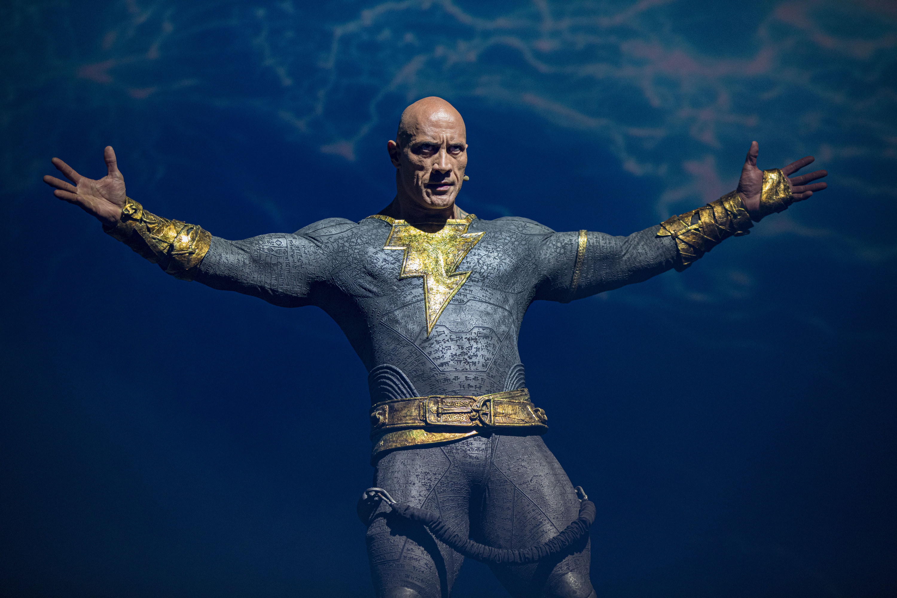 Dwayne wears his Black Adam costume on stage at an event