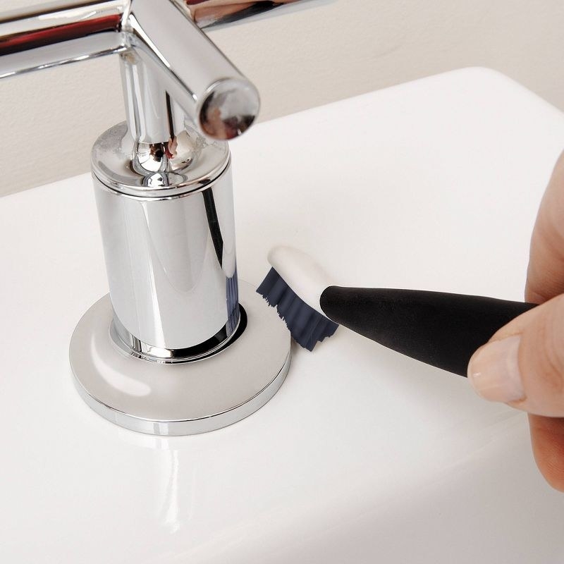 a model using the black and white brush on a sink tap