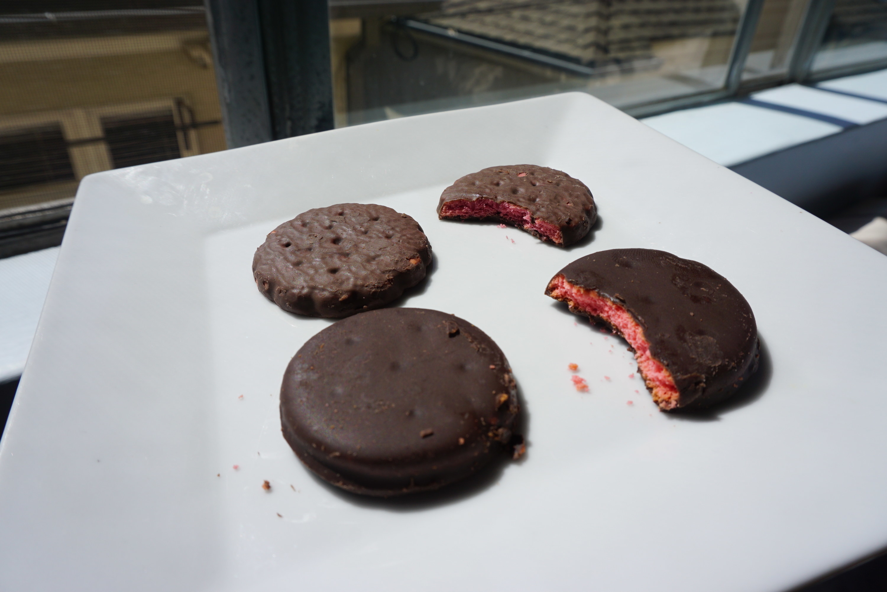 The two versions of the raspberry cookie on a plate beside each other; the smooth version looks bigger than the other