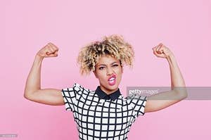 woman flexing on pink background