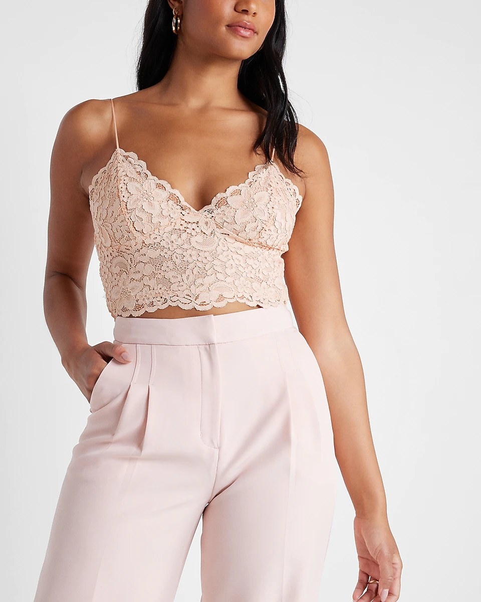 A model wearing the crop top in the color Pale Pink, styled with pale pink high-waisted trousers