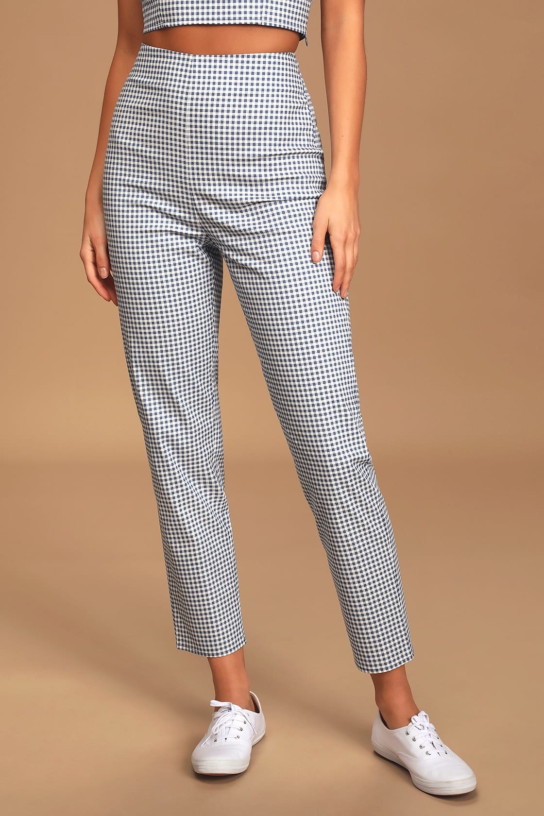 Model wearing blue and white checkered high waisted pant with white sneakers