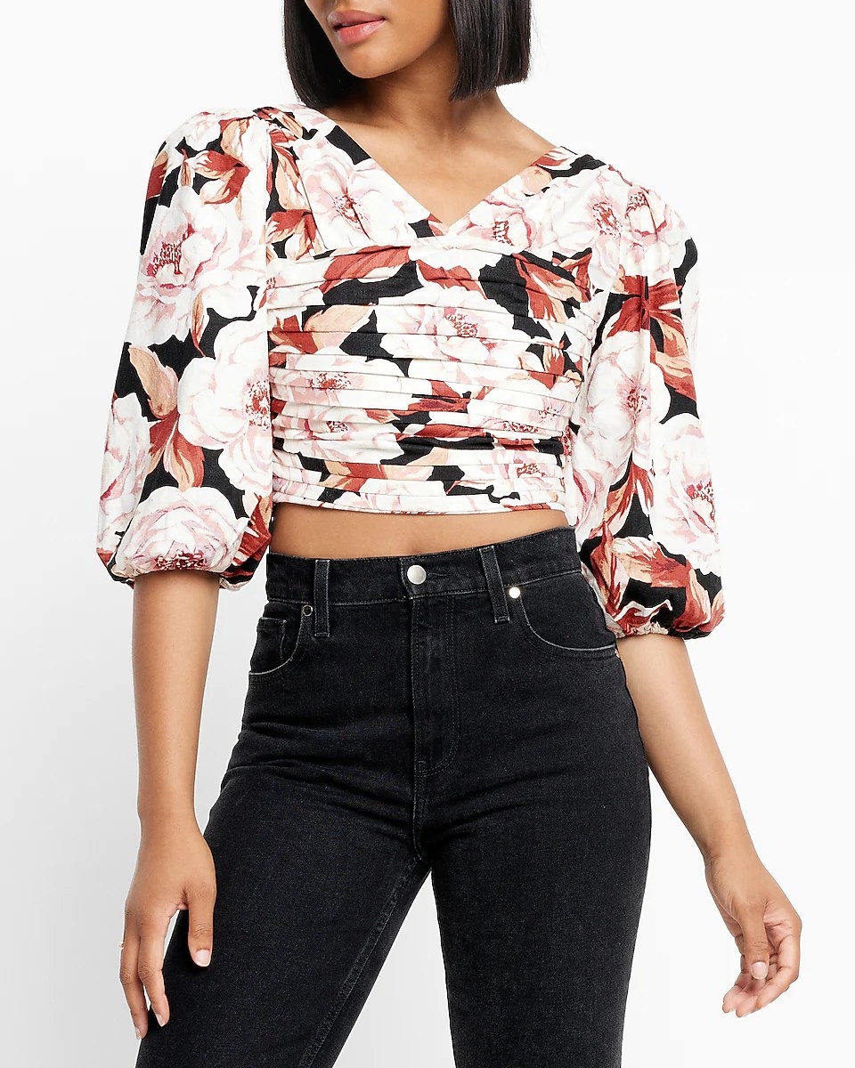 A model wearing the crop top with black high-waisted jeans