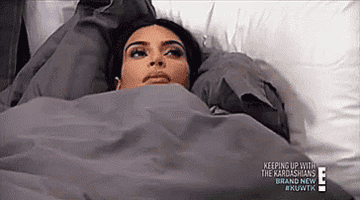 Gif of Kim Kardashian laying in bed on &quot;Keeping Up With The Kardashians&quot;