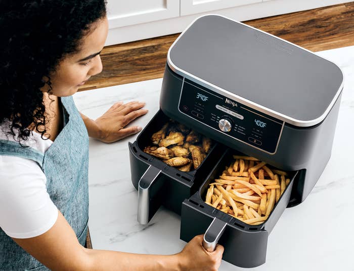 the air fryer cooking chicken wings and french fries
